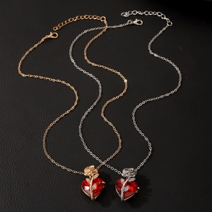 Gothic heart pendant necklace with red gemstone and rose detail in gold and silver