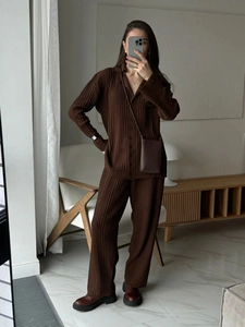 Close-up of dark brown pleated fabric texture on a modern knitted two-piece set