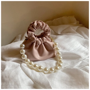 Detailed view of pink pleated cloud bag for girls with elegant pearl bead handle strap