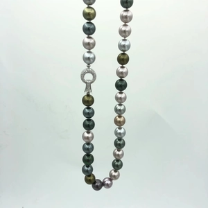 Detailed macro view of Tahitian pearl necklace with a sparkling diamond-set silver clasp
