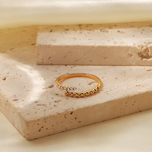 Dettaglio dell'anello aperto placcato oro 18K con cristalli e perline dorate graduate