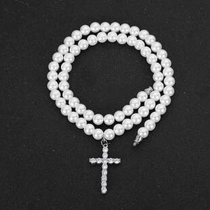 Close-up of pearl necklace with a silver cross pendant inlaid with clear diamonds