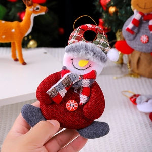 Detail of fabric snowman ornament with striped scarf and red buttons on Christmas tree