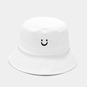 Détail de la broderie sourire sur un bob en coton blanc avec surpiqûres renforcées