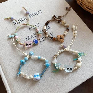 Detail of four handmade ceramic beaded bracelets with cute cartoon cats and dogs designs