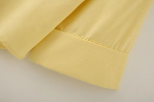 Close-up of yellow linen blend shirt sleeve cuff showing fabric texture and stitching