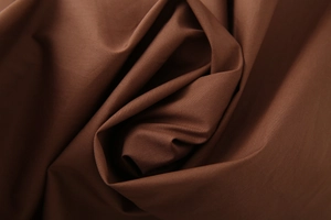 Makro-Detail von dunkelbraunem Leinwandgewebe aus Textil mit weichen Falten und Textur