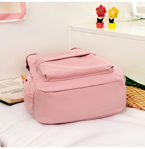 Detailed view of pink school backpack with rabbit ears texture on soft white bedding