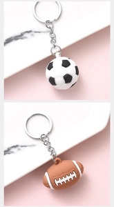 Detailed view of soccer and rugby ball keychains with metallic rings and soft texture