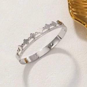 Silver stainless steel open bangle featuring multiple clover motifs with zircon accents