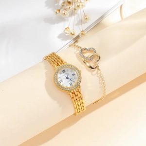 Close-up of gold women watch with starburst dial and matching heart charm bracelet