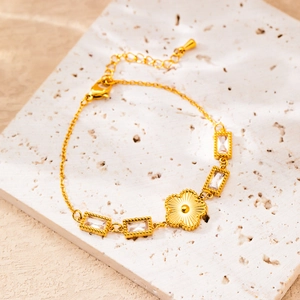 Detailed macro view of gold-plated star bracelet with rectangular stones and floral charms