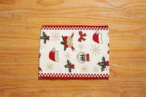 Detailed close-up of festive jacquard table runner featuring red snowflake and bell patterns