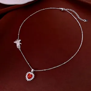 Vintage heart necklace with red zircon pendant and silver glove charm on velvet