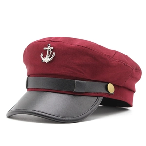 Dettaglio del cappello da capitano bordeaux con stemma ad ancora e visiera nera opaca