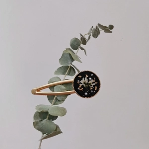 Vintage gold metal hair clip with black resin inlay featuring dried flowers and gold foil