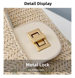 Detail of woven straw bag showing green floral embroidery and gold metal twist lock