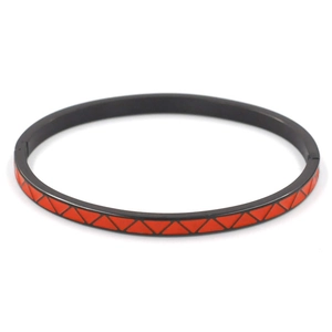 Detail view of 4mm black stainless steel bangle with red enamel triangle patterns