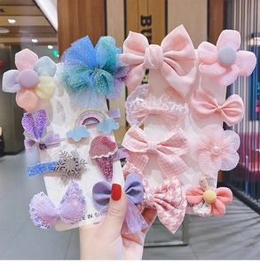 Detailed view of kids' hair clips set featuring colorful bowknots and floral patterns