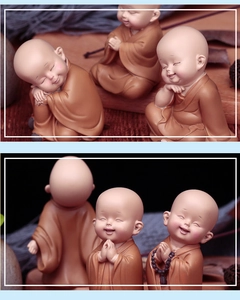 Detail view of cute monk dashboard ornaments in praying and nodding poses