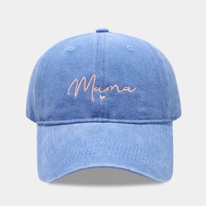 Close-up of pink Mama embroidery on washed blue denim baseball cap showing fabric texture