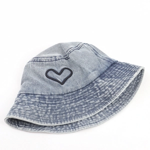 Détail de la broderie de cœur sur le chapeau bob en denim bleu clair délavé