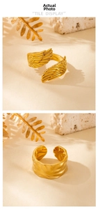 Detailed view of gold stainless steel wing ring and textured wide band on natural stone