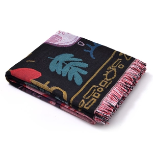 Close-up of thick knitted fabric texture with colorful tassels and geometric patterns