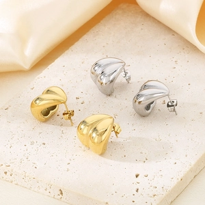Irregular heart shaped gold and silver stainless steel studs on stone background