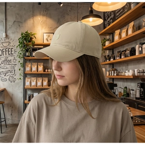 Detail of breathable laser-cut holes on a khaki baseball cap with S-shield logo
