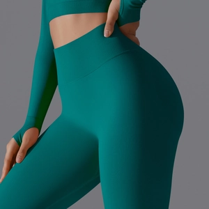 Detail of dark green seamless knit yoga leggings and crop top with high ribbed waistband