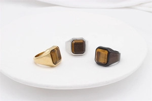 Macro view of men's square tiger eye signet rings in gold, silver and black finishes