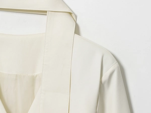 Dettaglio di un blazer crema con cuciture di alta qualità e raffinato scollo a V