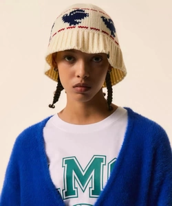 Detailed close-up of crochet knit bucket hat with peace dove jacquard and plush blue cardigan