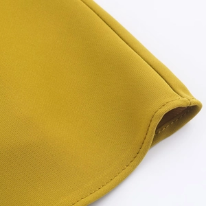 Detailed close-up of double-stitched hem on mustard yellow woven fabric top