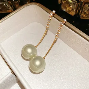 Elegant gold drop earrings with shimmering zircon pave and large light green pearls