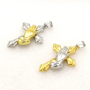 Detailed close-up of religious cross pendants with praying hands in gold and silver finish