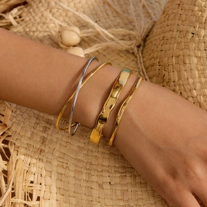Set of four gold and silver stainless steel bangles styled with a summer straw hat