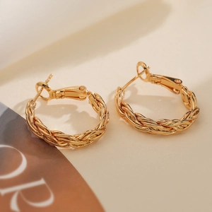 Détail de créoles plaquées or 18 carats avec un design sophistiqué de corde tressée