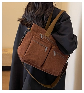 Detail of caramel brown corduroy crossbody bag with multiple pockets and ribbed texture