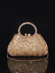Detail of luxury gold evening bag with champagne rhinestones and round handle