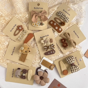 Flat lay of brown and beige fabric hair clips with floral and plaid patterns for girls
