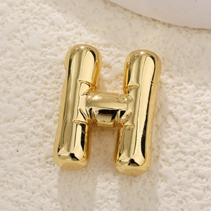 Detailed macro of gold-plated puffy letter H balloon pendant with polished mirror finish