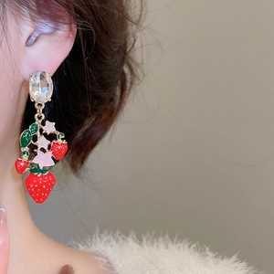Detail of strawberry drop earring with red enamel and crystals worn by a model