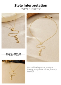 Detailed macro view of gold chain tassel necklace featuring sparkling zircon heart pendants