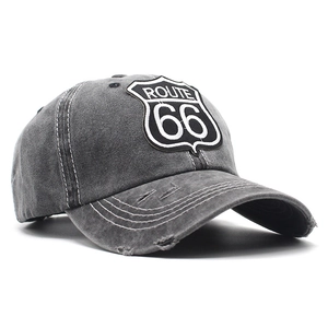 Detailed close-up of vintage Route 66 patch and distressed denim texture on baseball cap