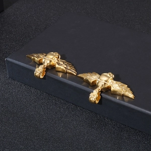 Vue détaillée de pendentifs ailes d'ange dorées avec relief de crâne et plumes