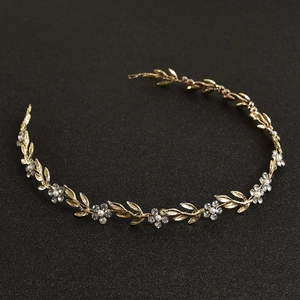 Détail d'un bandeau de mariée fait main avec feuilles dorées, perles et cristaux