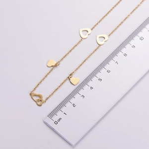 Detail showing the 18K gold heart pendant dimensions with ruler measurement measurement