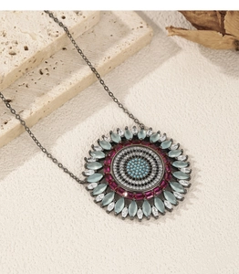 Macro view of sunflower-shaped pendant with multi-color zircon inlay on black chain